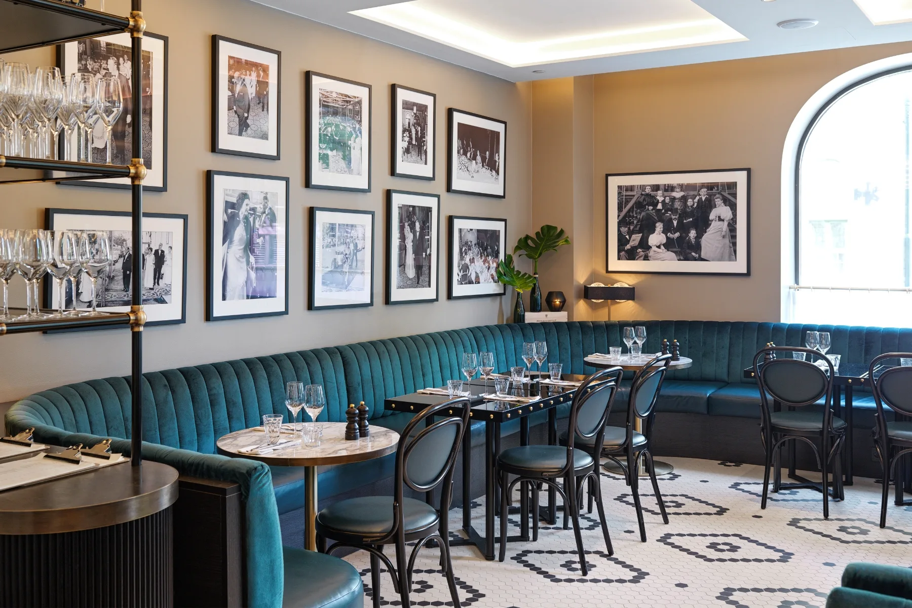 the restaurant interior features contract furniture with blue couches and framed pictures.